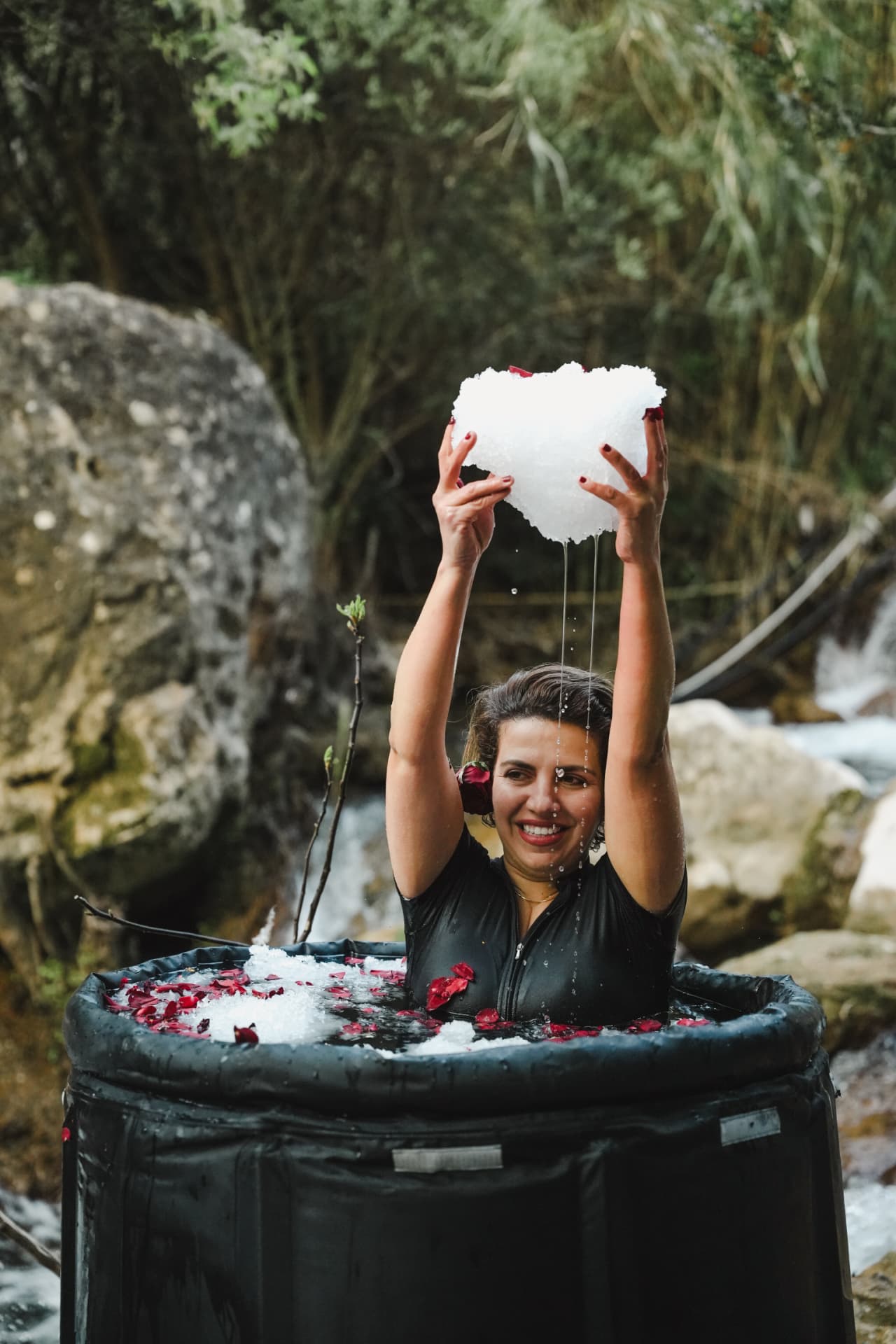 Zainab holding a large piece of ice above her head